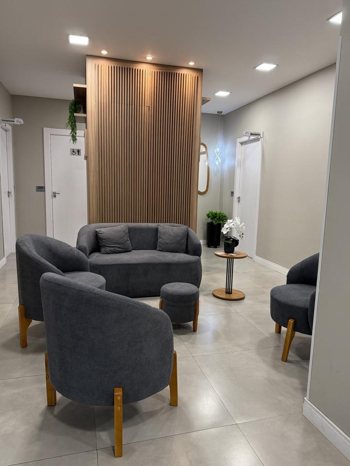 Sala de espera da iClinic com poltronas e painel de madeira